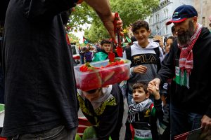 Watermelon is handed out at a ceasefire now rally in Melbourne.