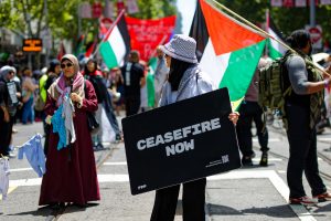 Woman holding a ceasefire now sign in Melbourne.
