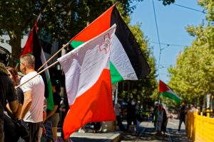 Man flying the Maltese flag in support of Palestinians