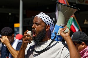 Man leading the ceasefire now chant.