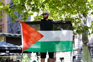 Man flies Palestinian flag from a high vantage point.