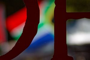 Looking out from a coffee shop at a South African flag flying in the State Library forecourt, Naarm (Melbourne).